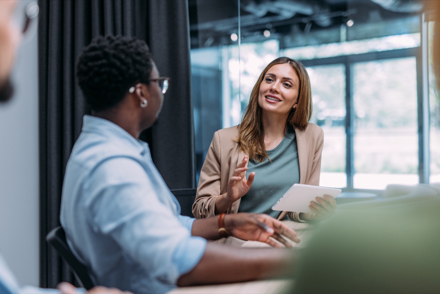 HR professionals in conversation with a tablet